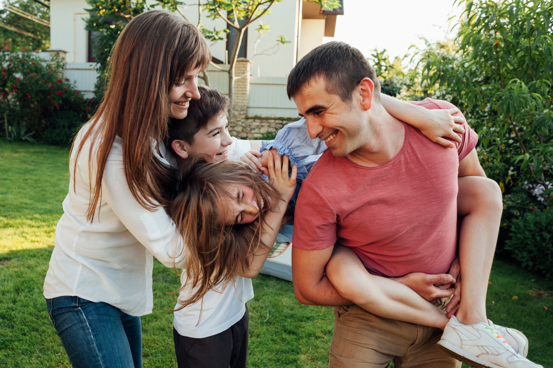 A family is playing in the backyard of their house.