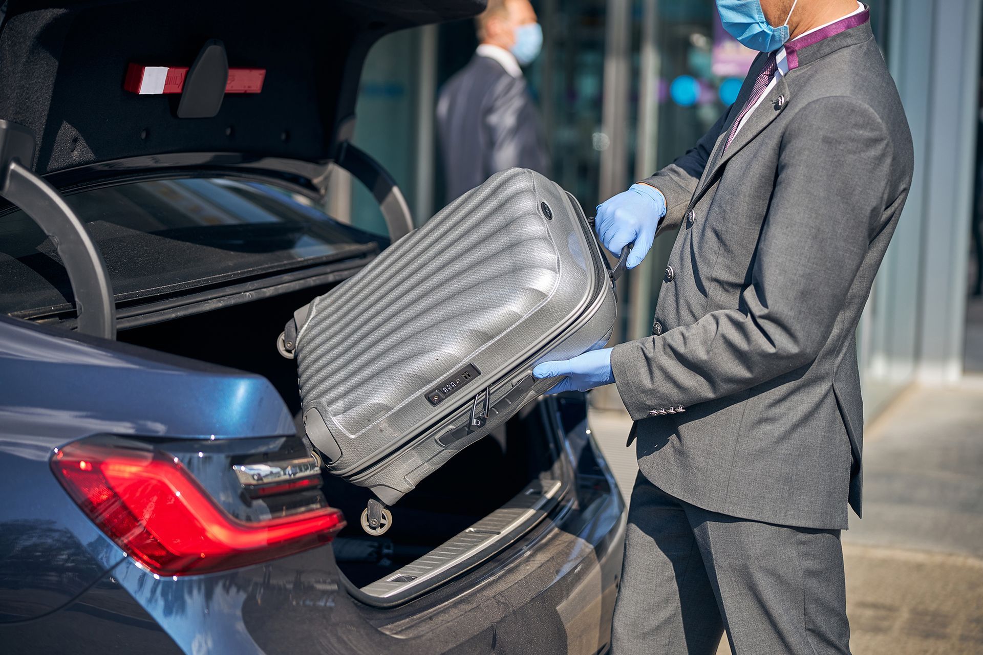 Chauffeur Packing Luggage Into Car