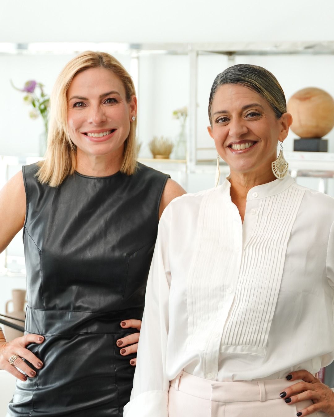 Woman in black dress with fringe, arms outstretched, standing in spotlight.