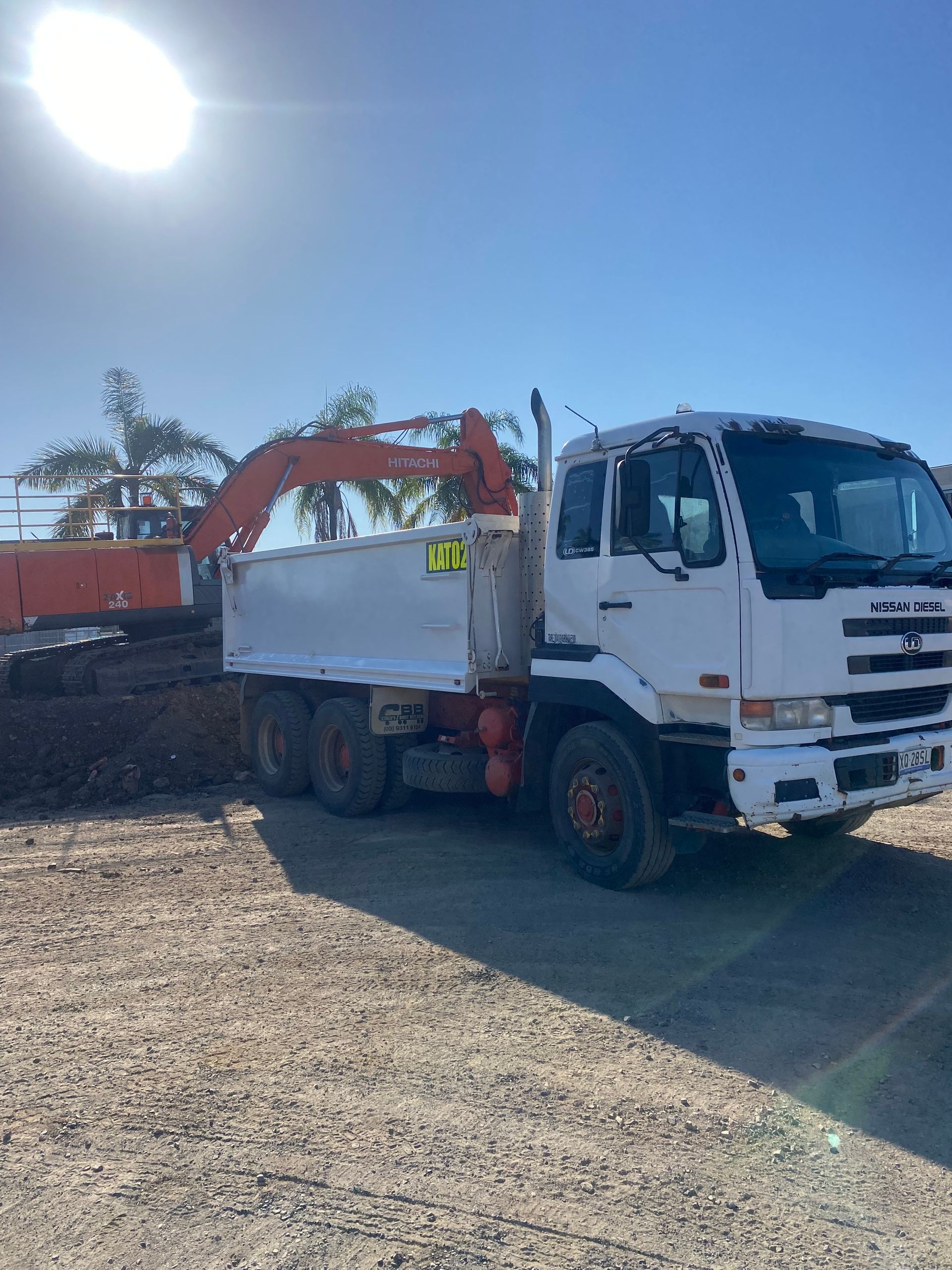 Yellow and Orange Excavator on A Construction Site, Scooping Dirt Under a Blue Sky — KAT Earthmoving In Nine Mile, QLD