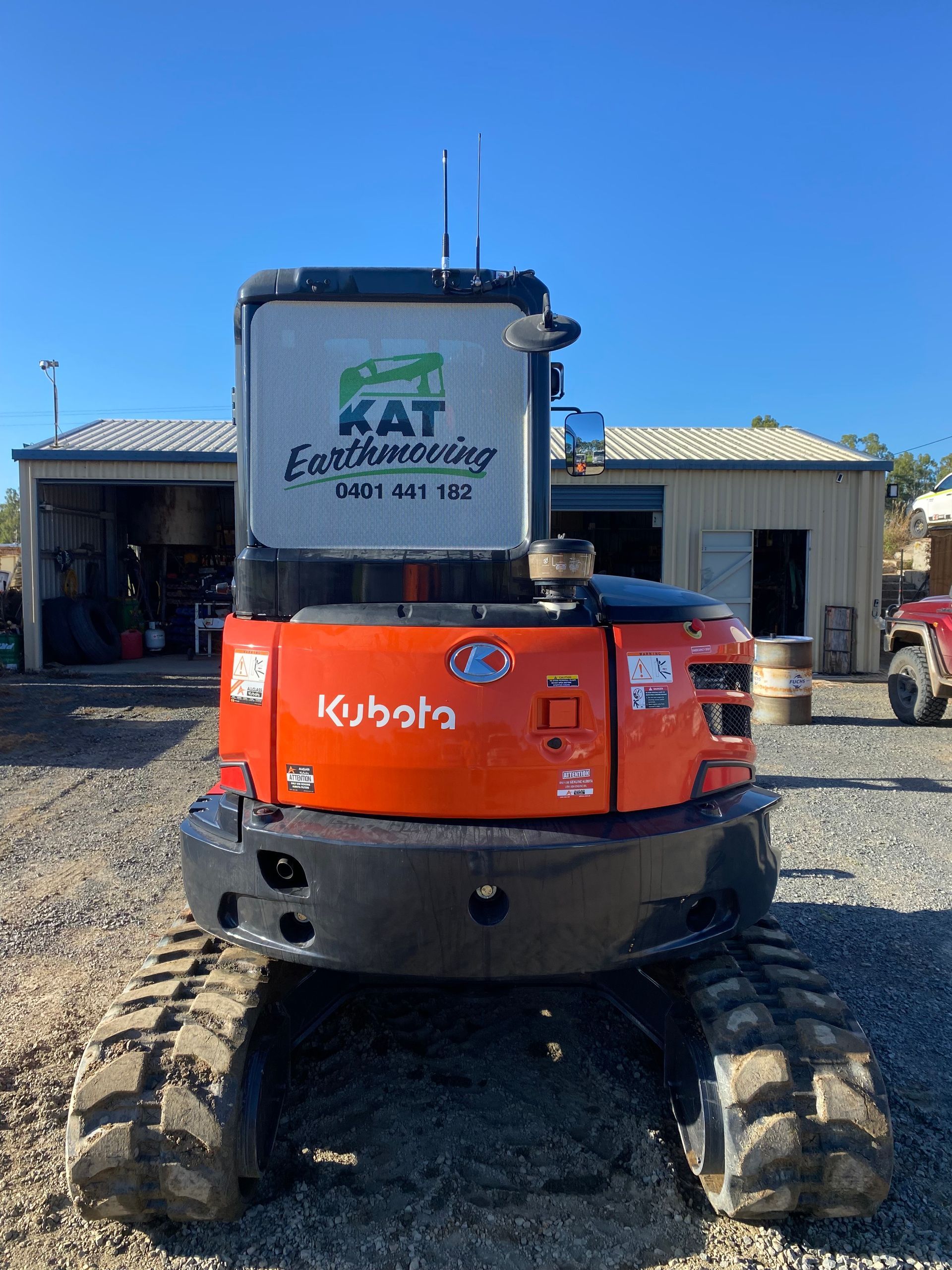 Yellow Excavator Dumping Debris Into a Truck at A Construction Site in A Residential Area — KAT Earthmoving In Nine Mile, QLD