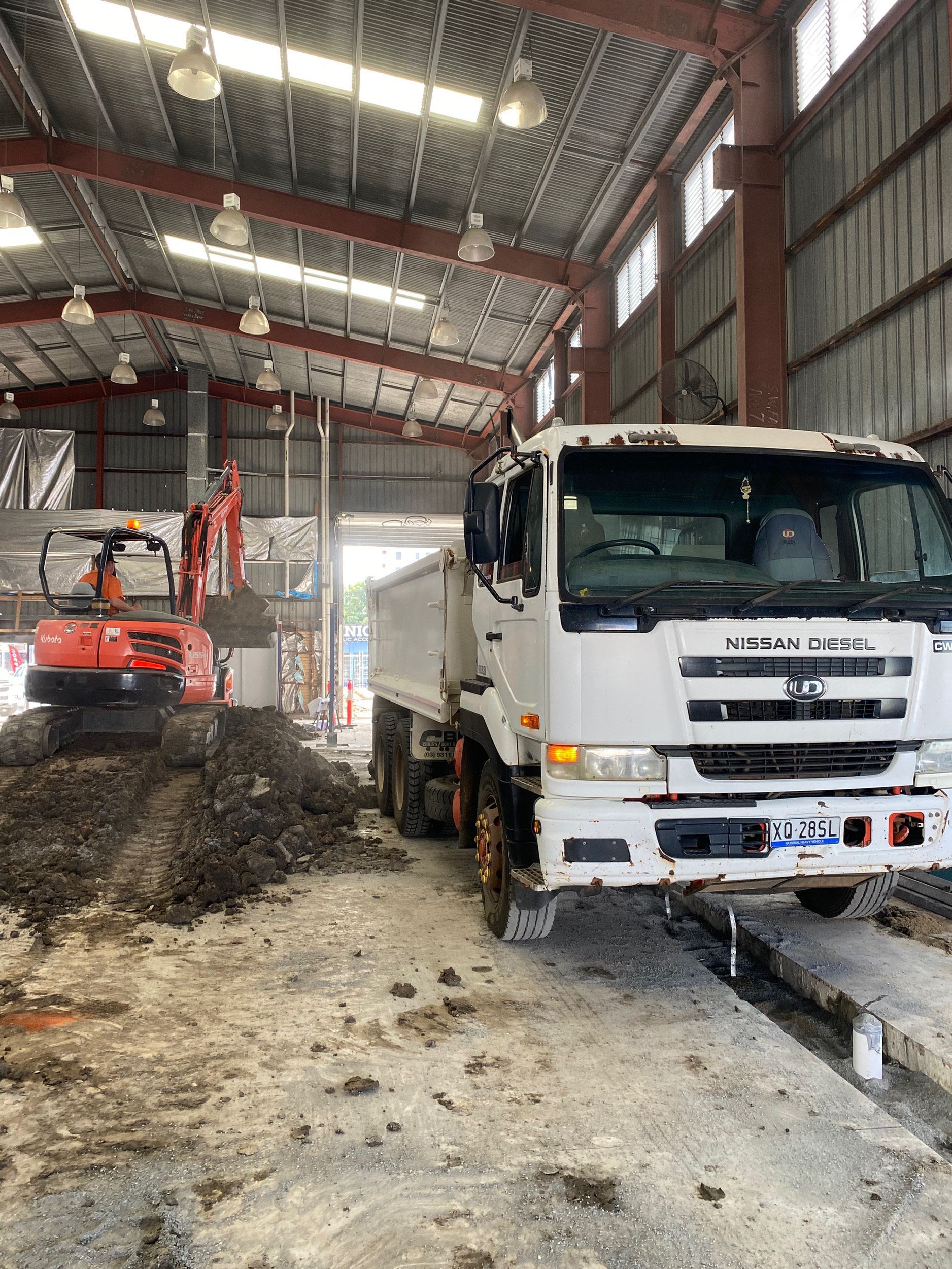 Yellow Backhoe Excavating Dirt on A Construction Site Under a Blue, Cloudy Sky — KAT Earthmoving In Nine Mile, QLD