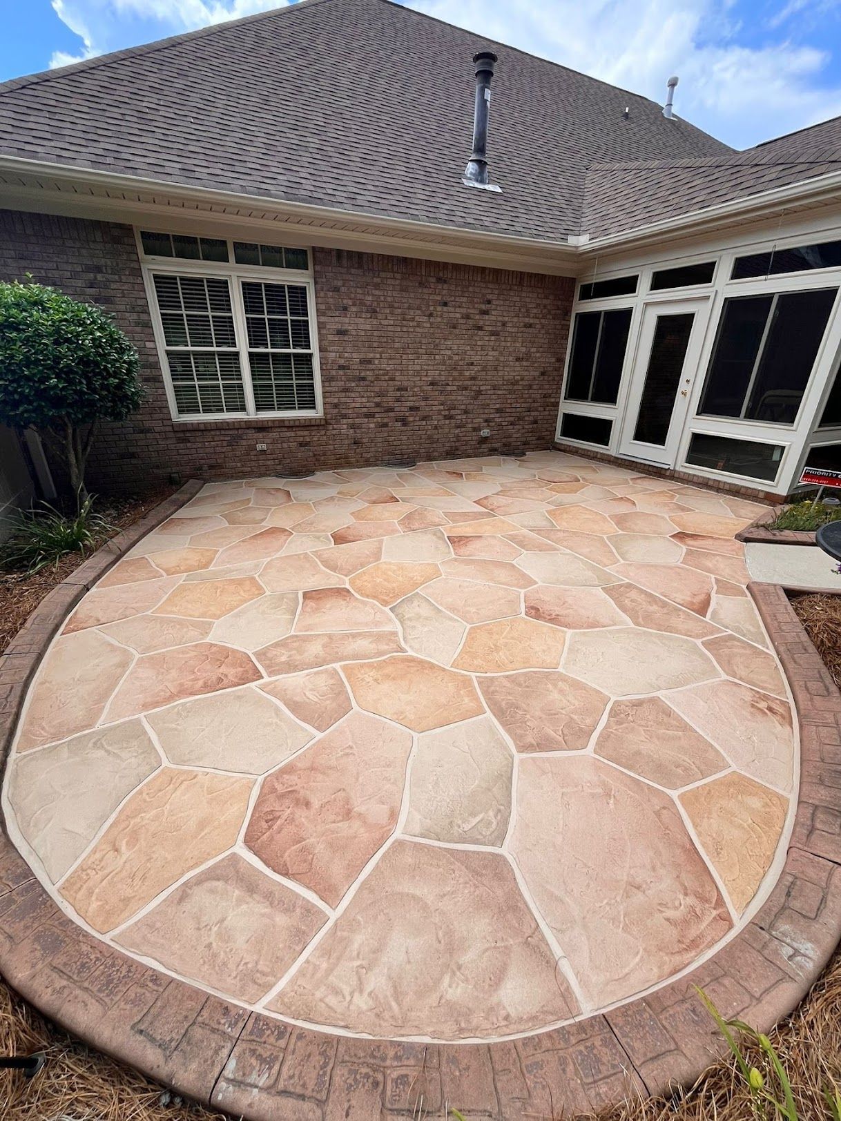 A large house with two garage doors and a concrete driveway.