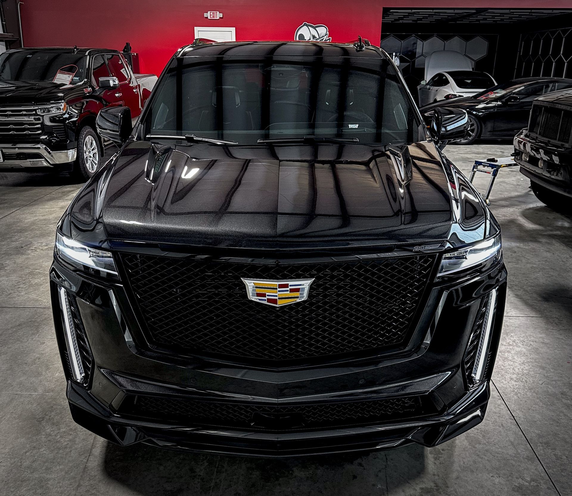A blue and white truck is parked in a garage.