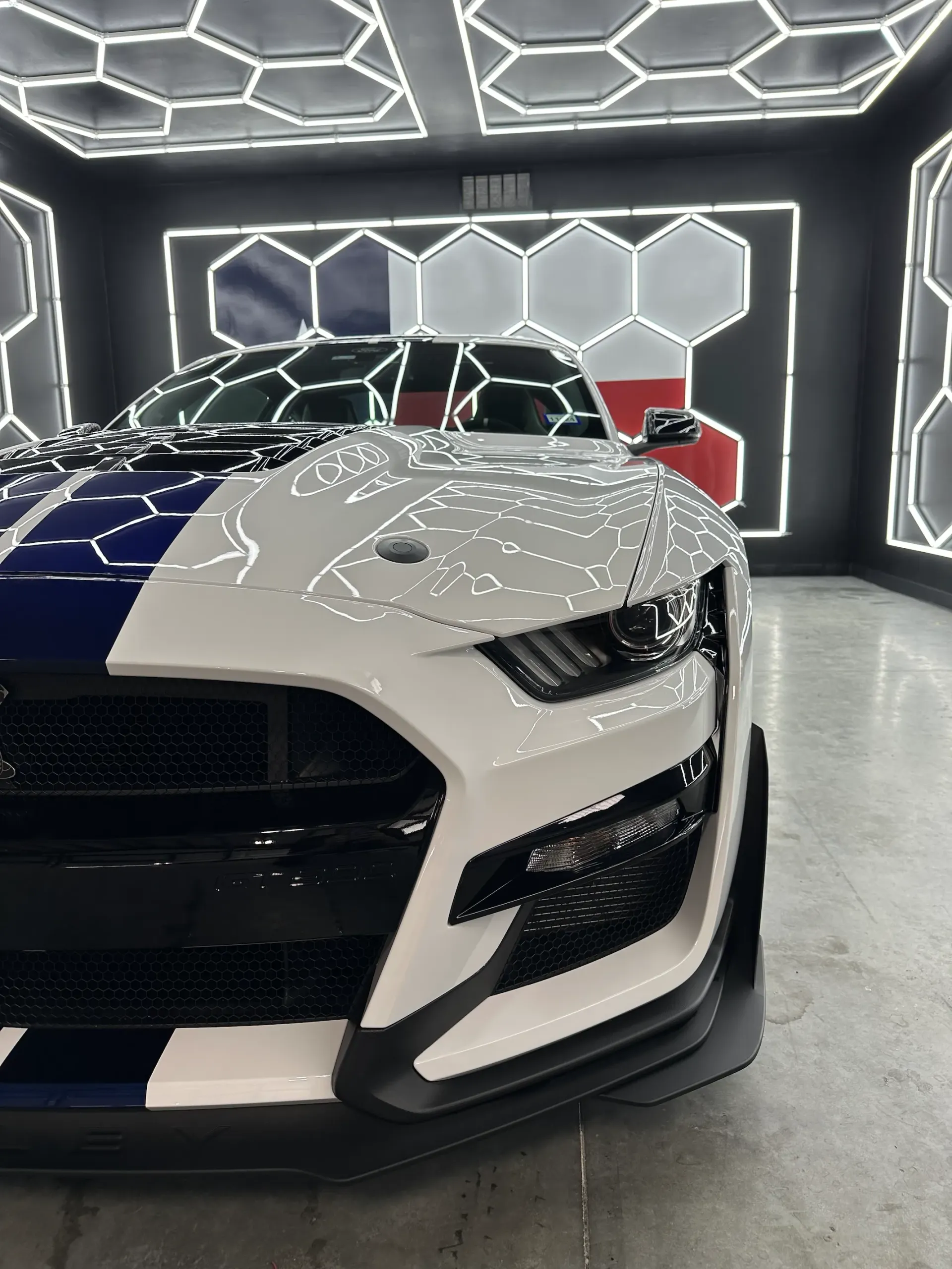 A blue and white truck is parked in a garage.