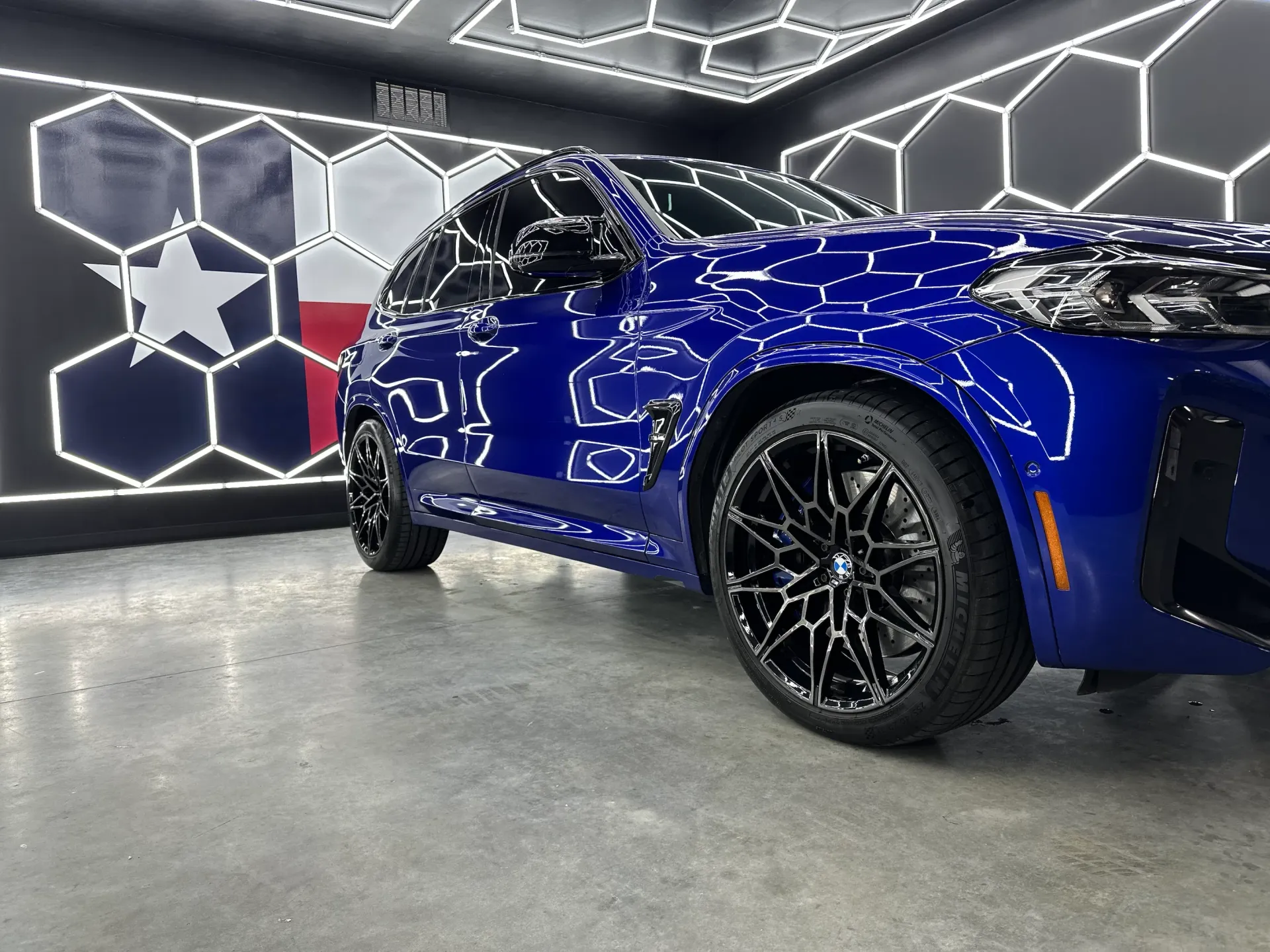 A blue and white truck is parked in a garage.