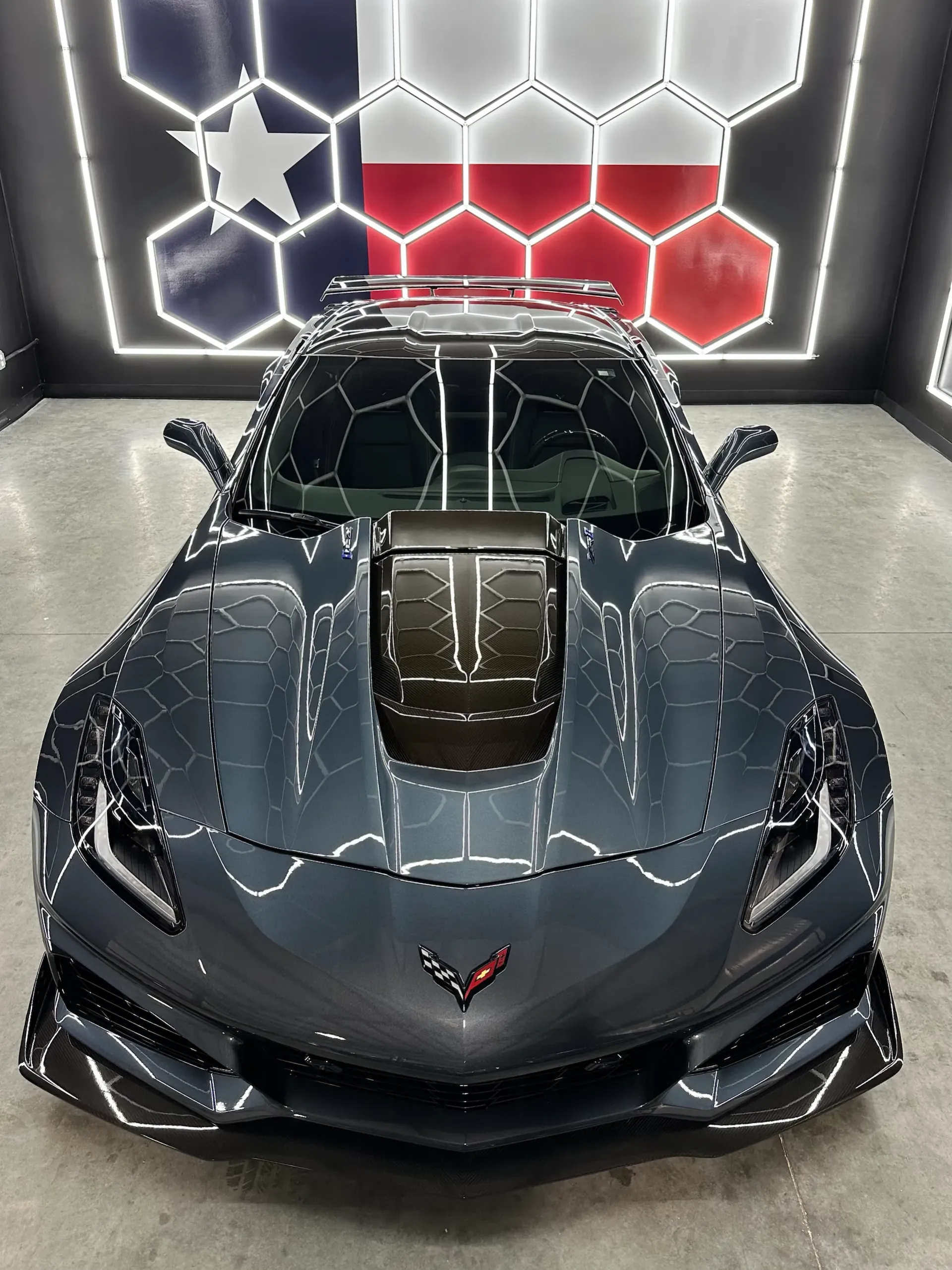 A blue car is parked in a parking lot