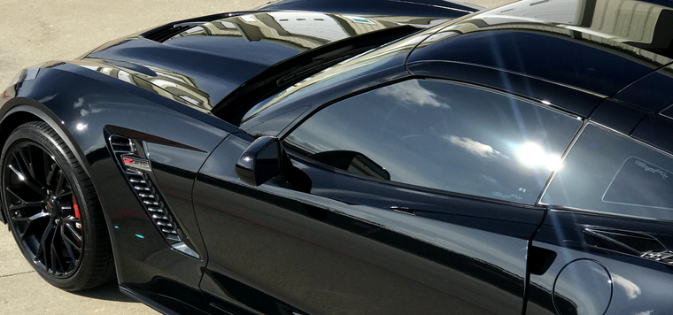 A black sports car is parked on the side of the road