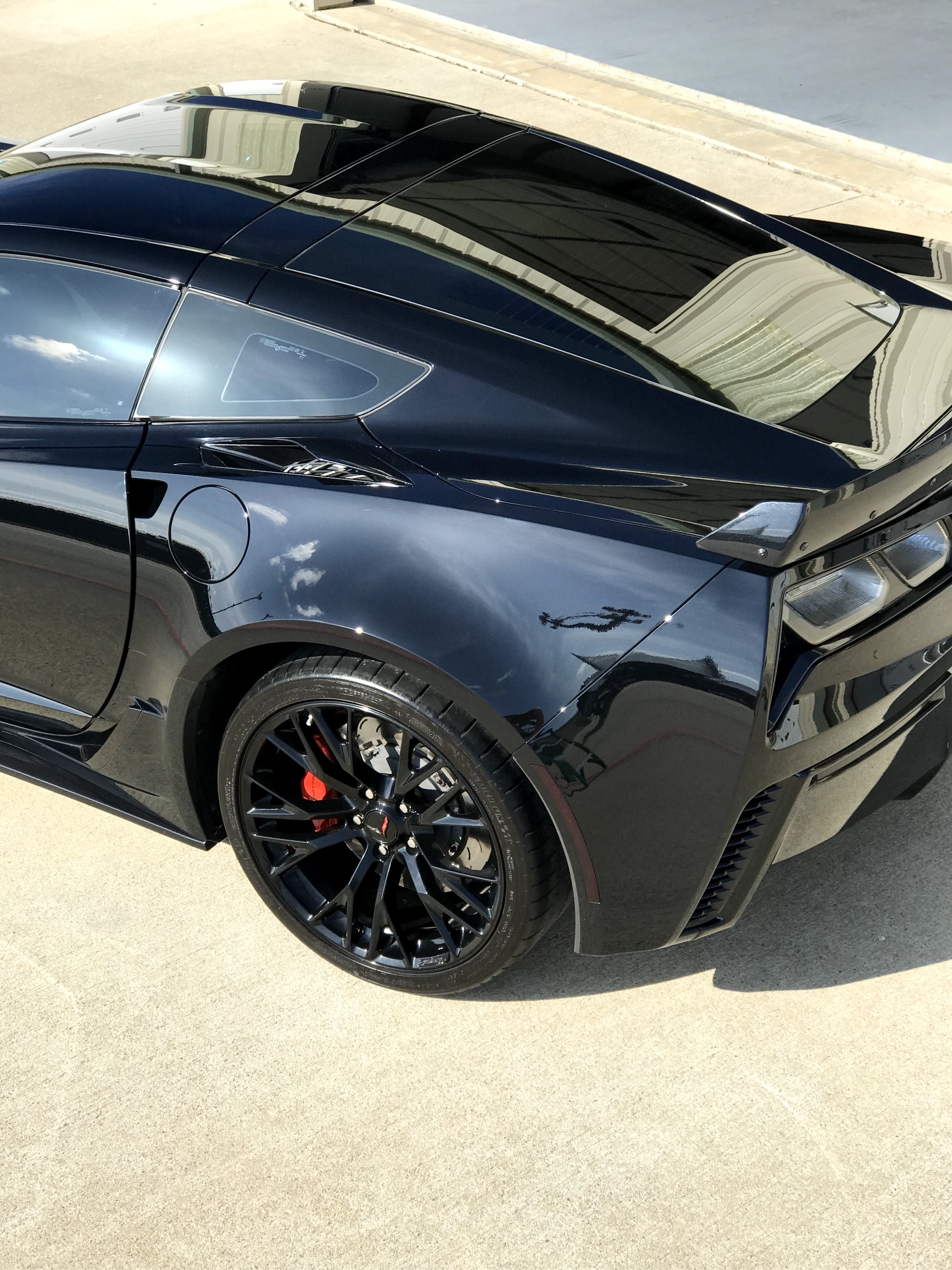 A red and black boat is parked in a garage.
