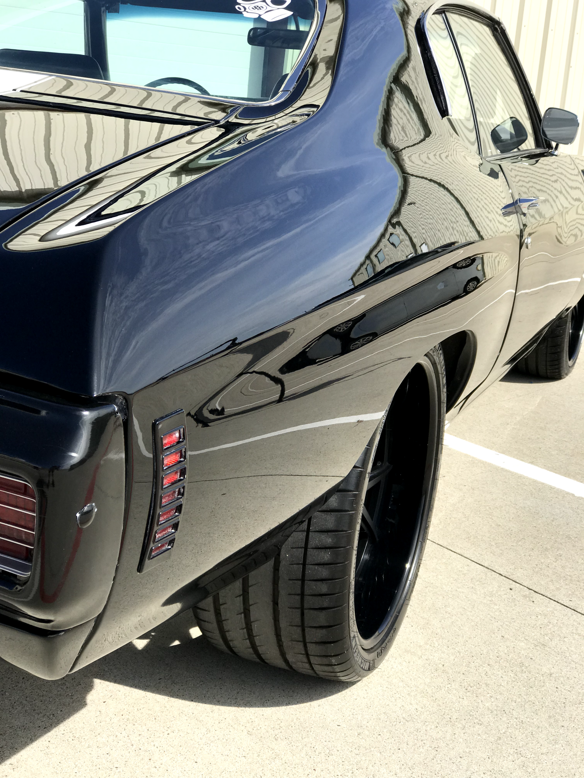 A black car is parked in a parking lot