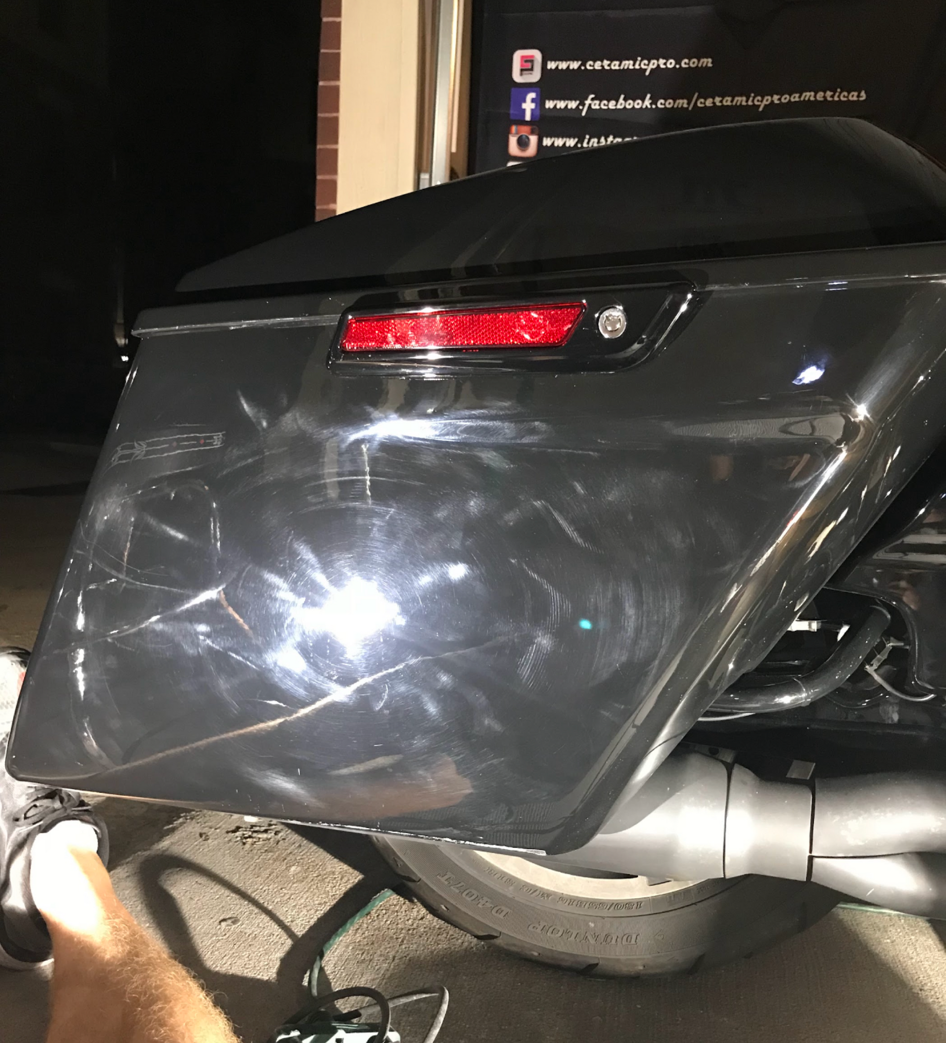 A close up of a motorcycle 's trunk with a red light on it.