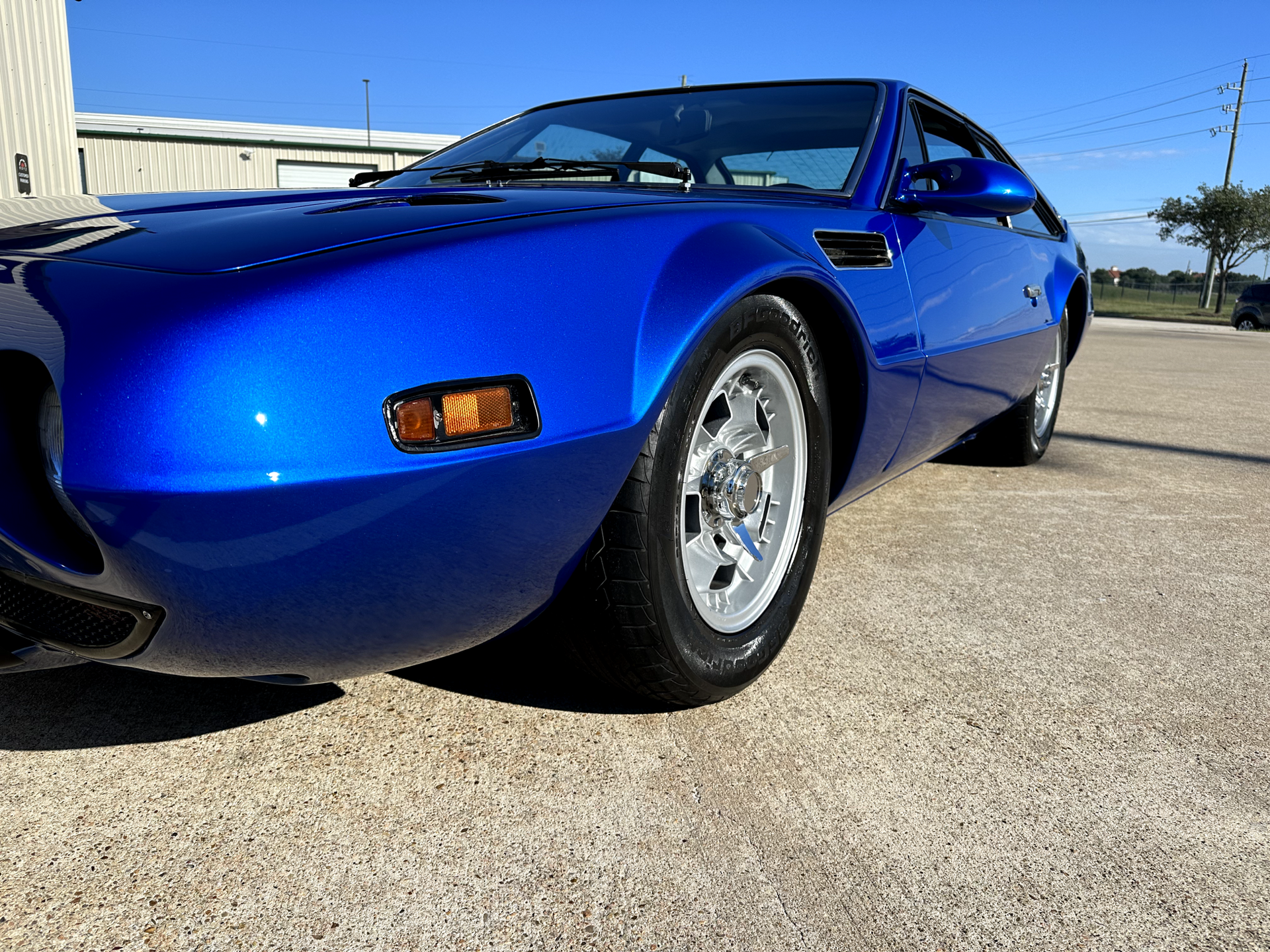 A blue sports car is parked in a parking lot.