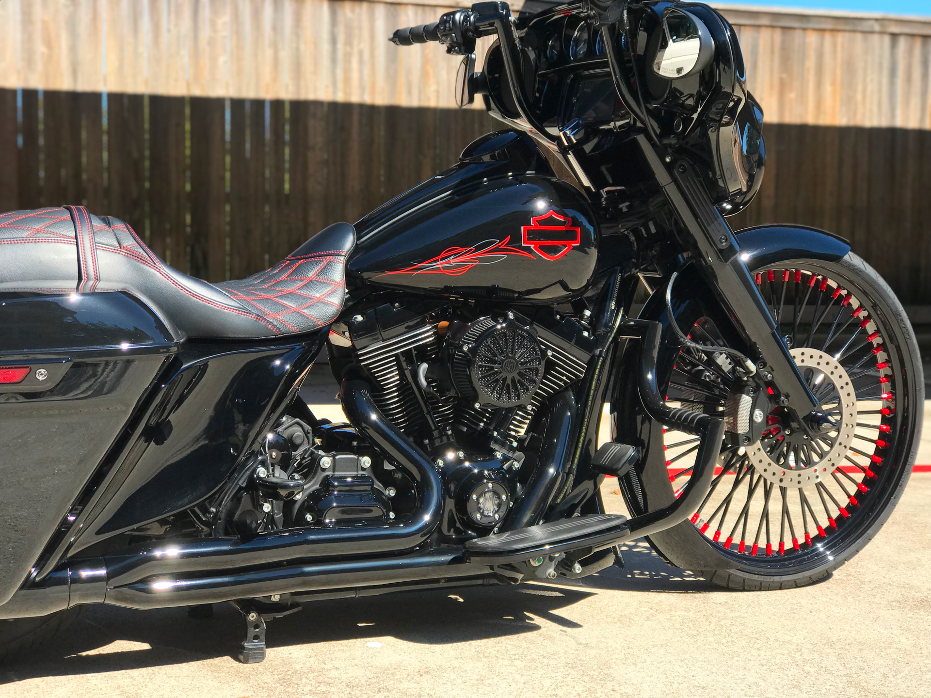 A black harley davidson motorcycle is parked in a parking lot.