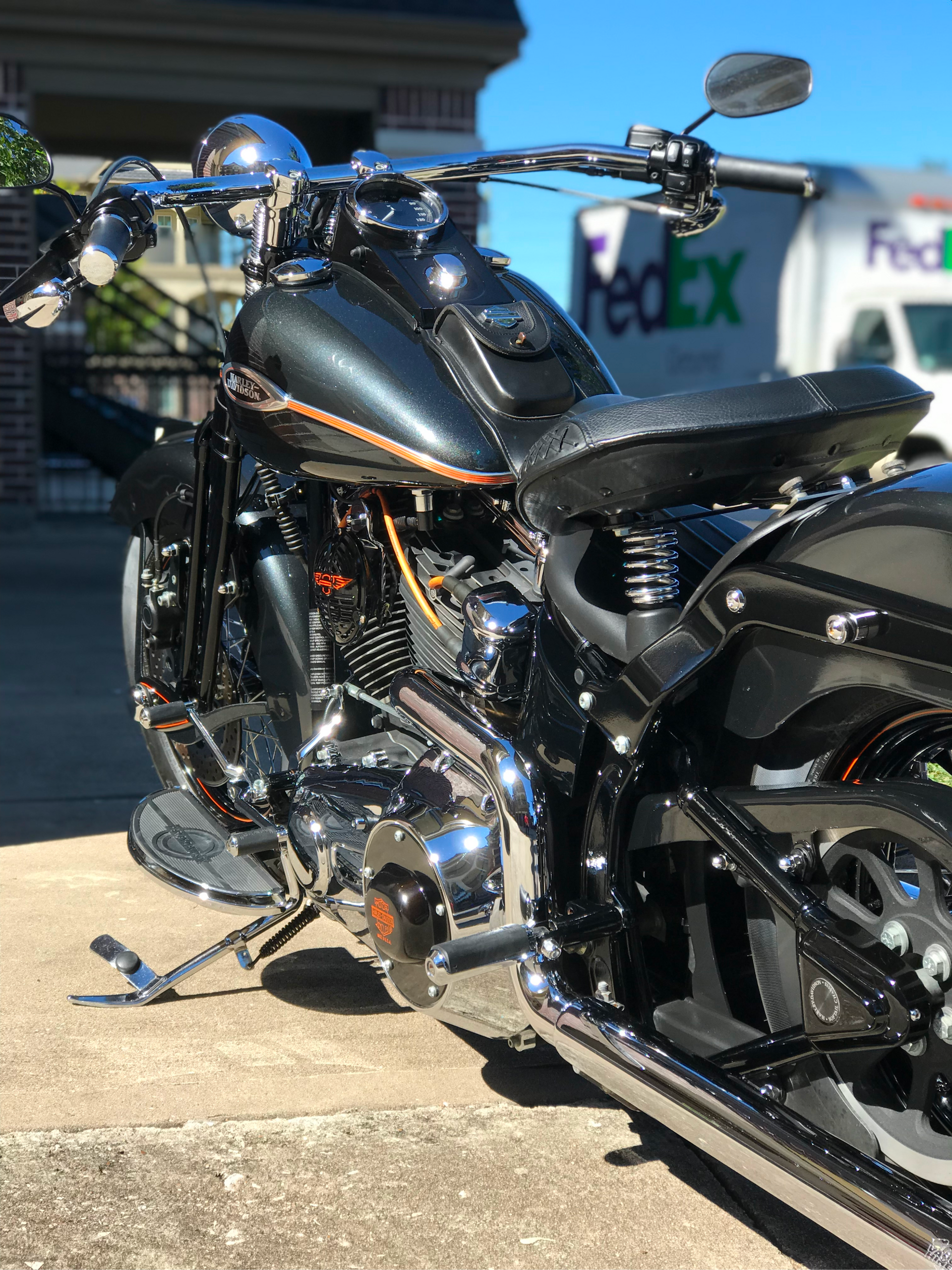 A black motorcycle is parked in front of a fedex truck.