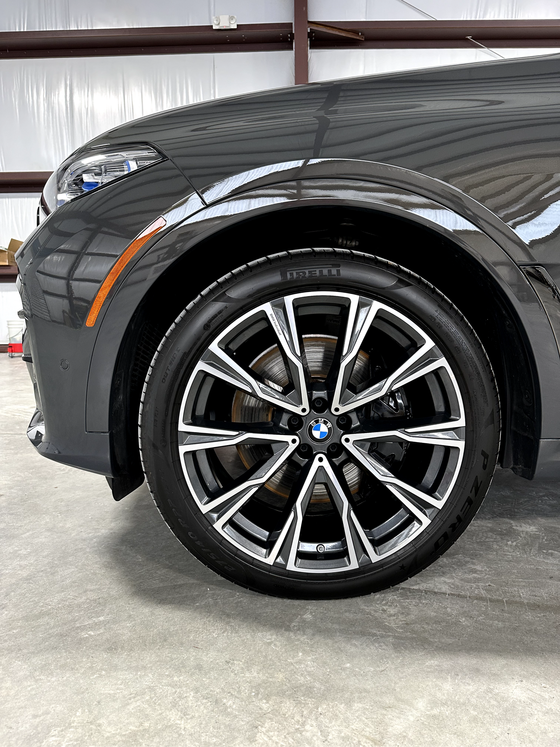 A close up of a car wheel in a garage.