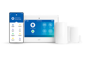 A security system is sitting on a table next to a tablet and a cell phone. A security system is sitting on a table next to a tablet and a cell phone.
