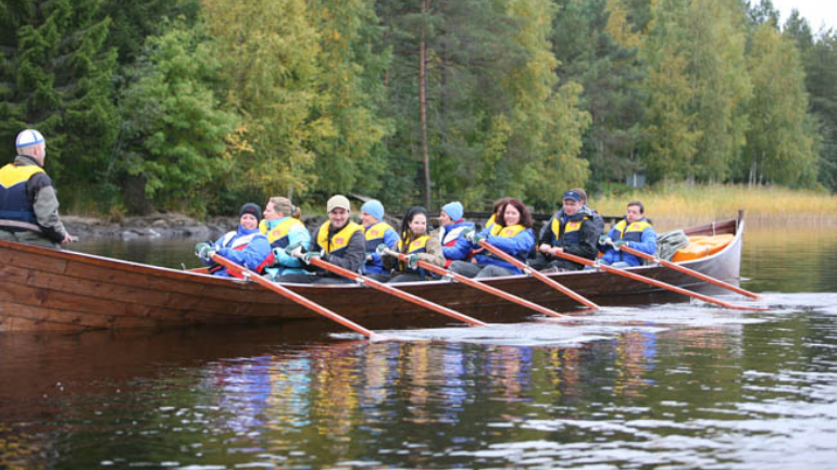 Teilnehmer rudern gemeinsam in einem Boot