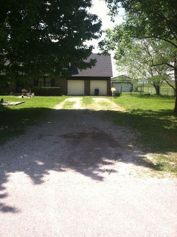 A driveway leading to a house with two garage doors