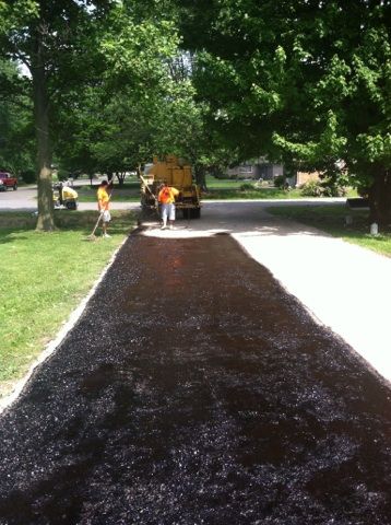 A group of people are working on a driveway