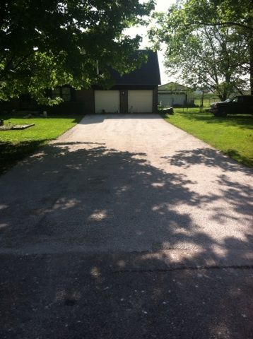 A driveway leading to a house with two garages