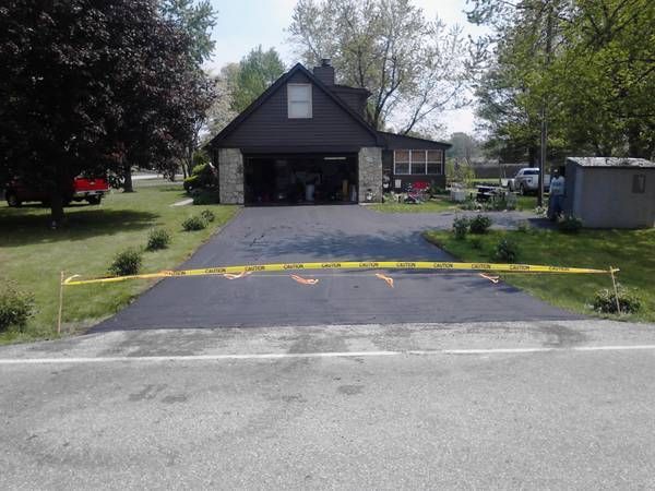 A house with a garage and a driveway with a yellow tape around it