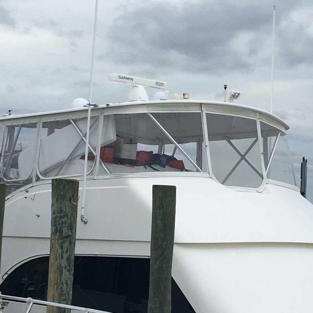 A white boat with a radar on top of it