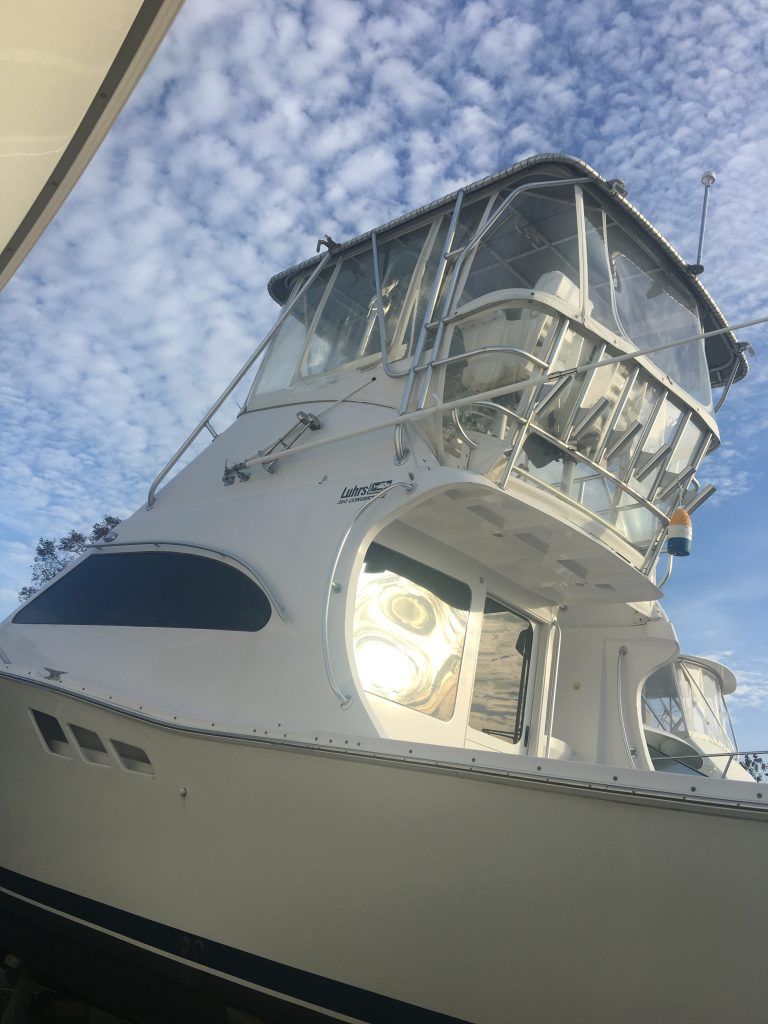 A white boat with a clear roof is sitting on top of a body of water.