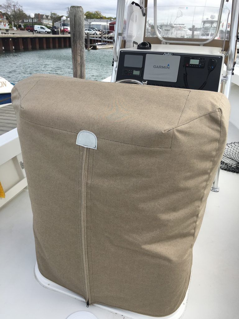 A boat with a seat cover on it is docked at a dock.