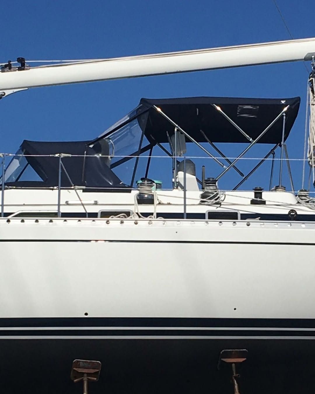 A white sailboat with a black canopy on top of it