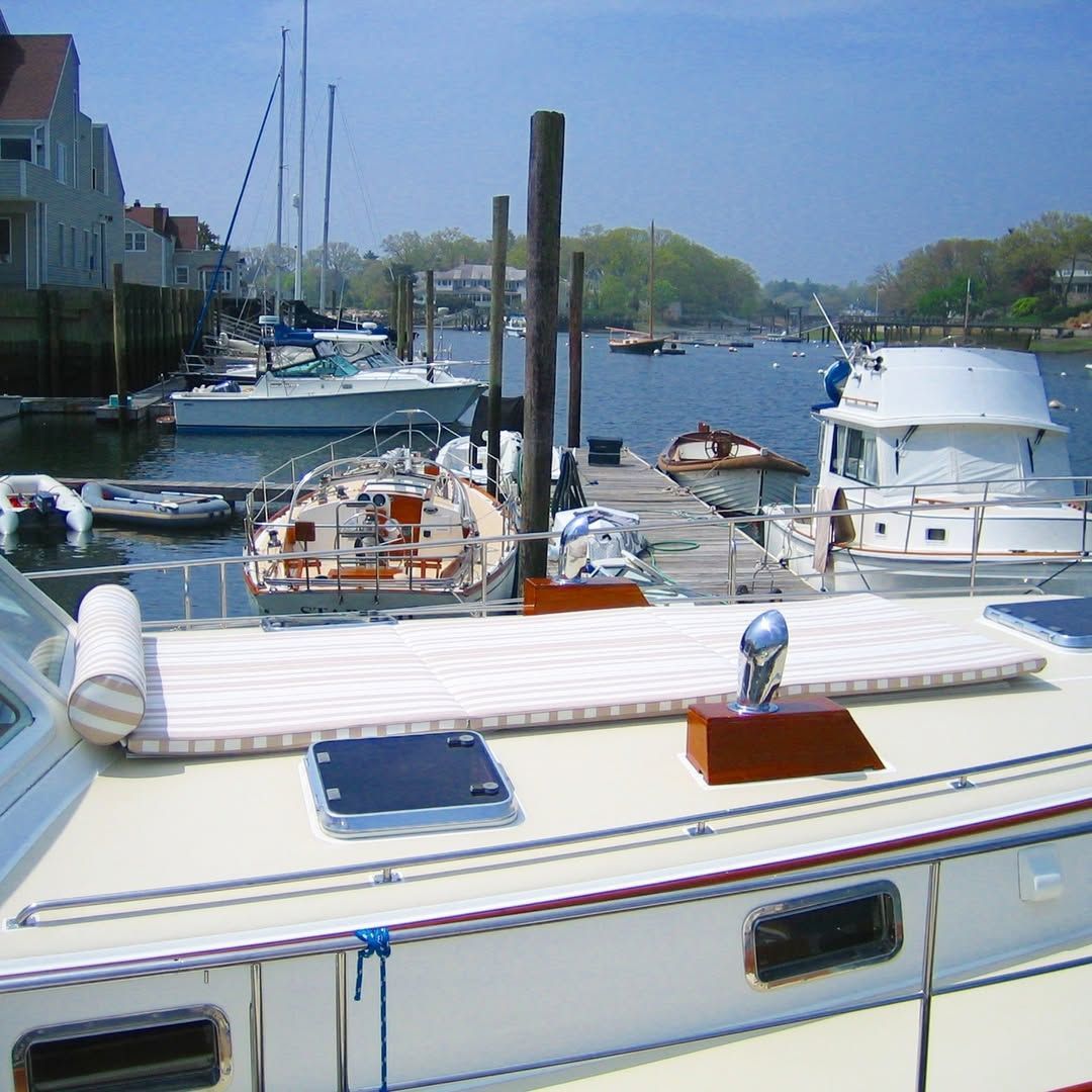Several boats are docked in a harbor on a sunny day