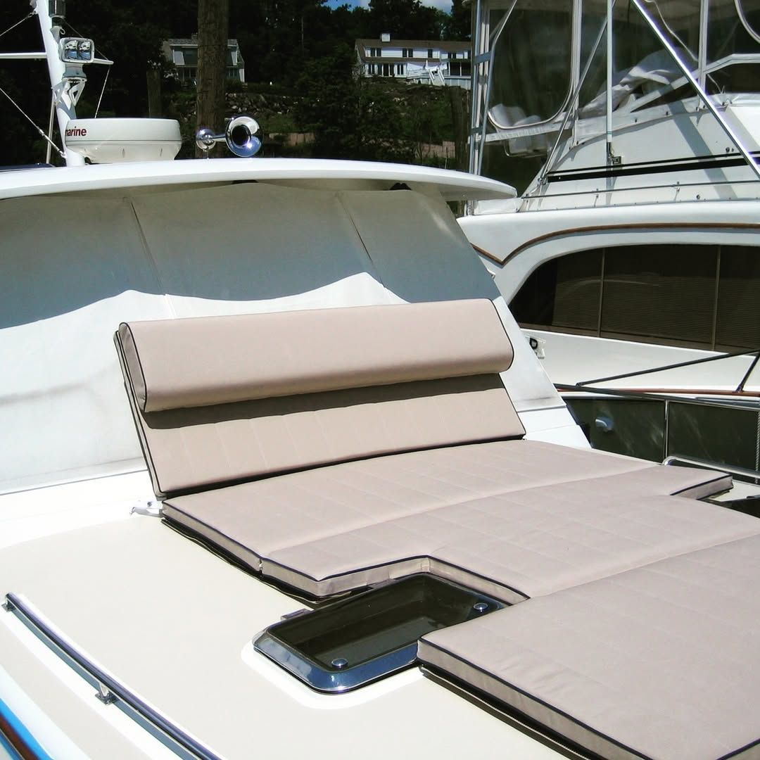 A boat with a tan cushion on the deck