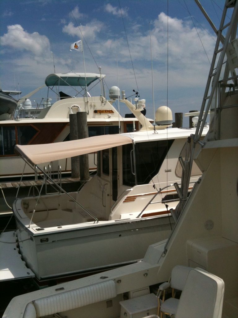 Several boats are docked in a marina on a sunny day