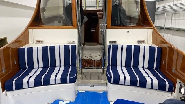 The inside of a boat with blue and white striped cushions