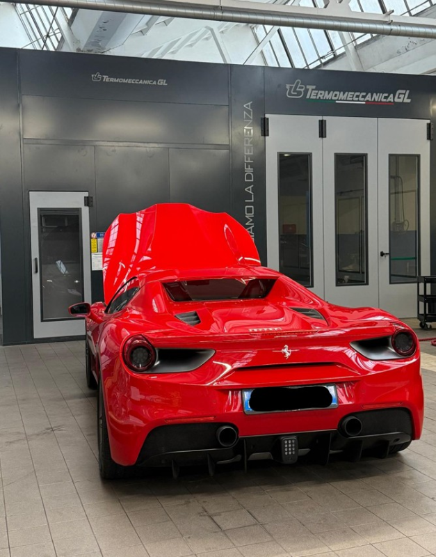 Donna sorridente mentre guida un'auto, sono presenti anche due uomini.