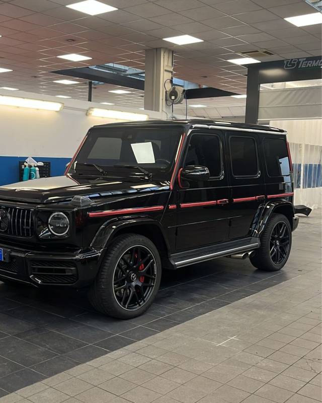 Una donna carica le valigie nel bagagliaio aperto dell'auto all'esterno.