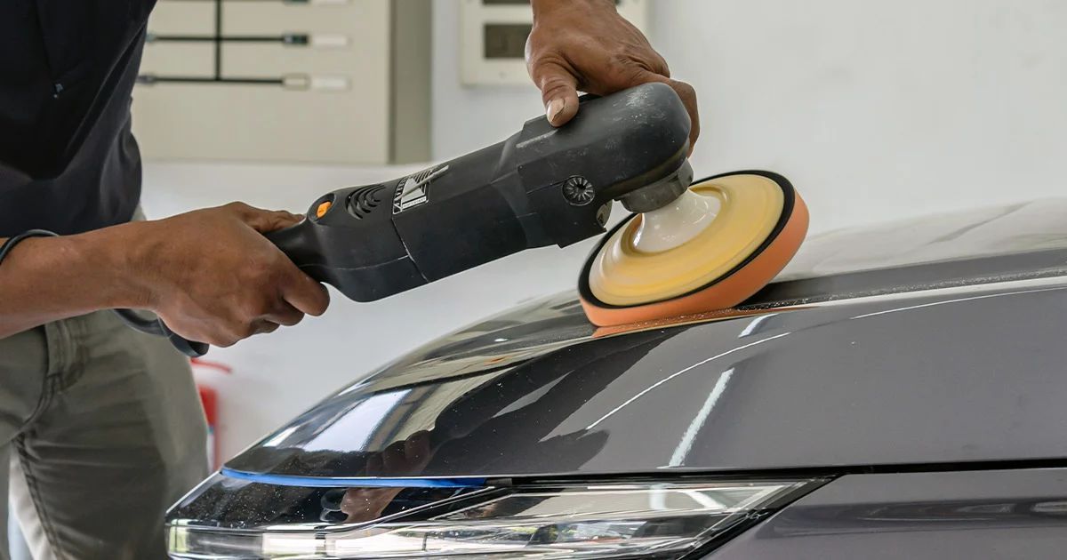 Un'auto sportiva rossa Ferrari California in un garage con pareti rosse e grigie.