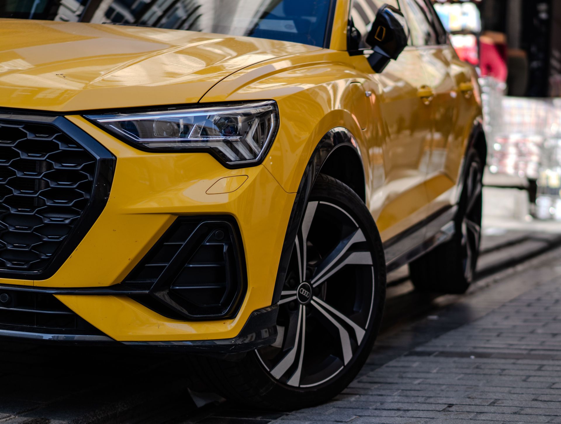 Auto sportiva rossa su sfondo nero, illuminata dal basso.