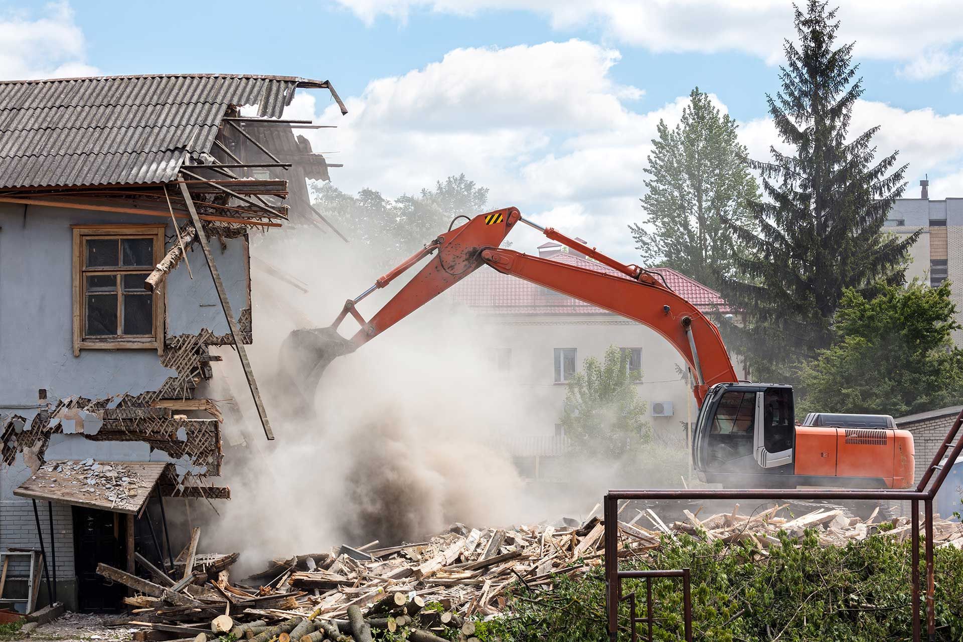 excavator working at the demolition of an old residential building 
