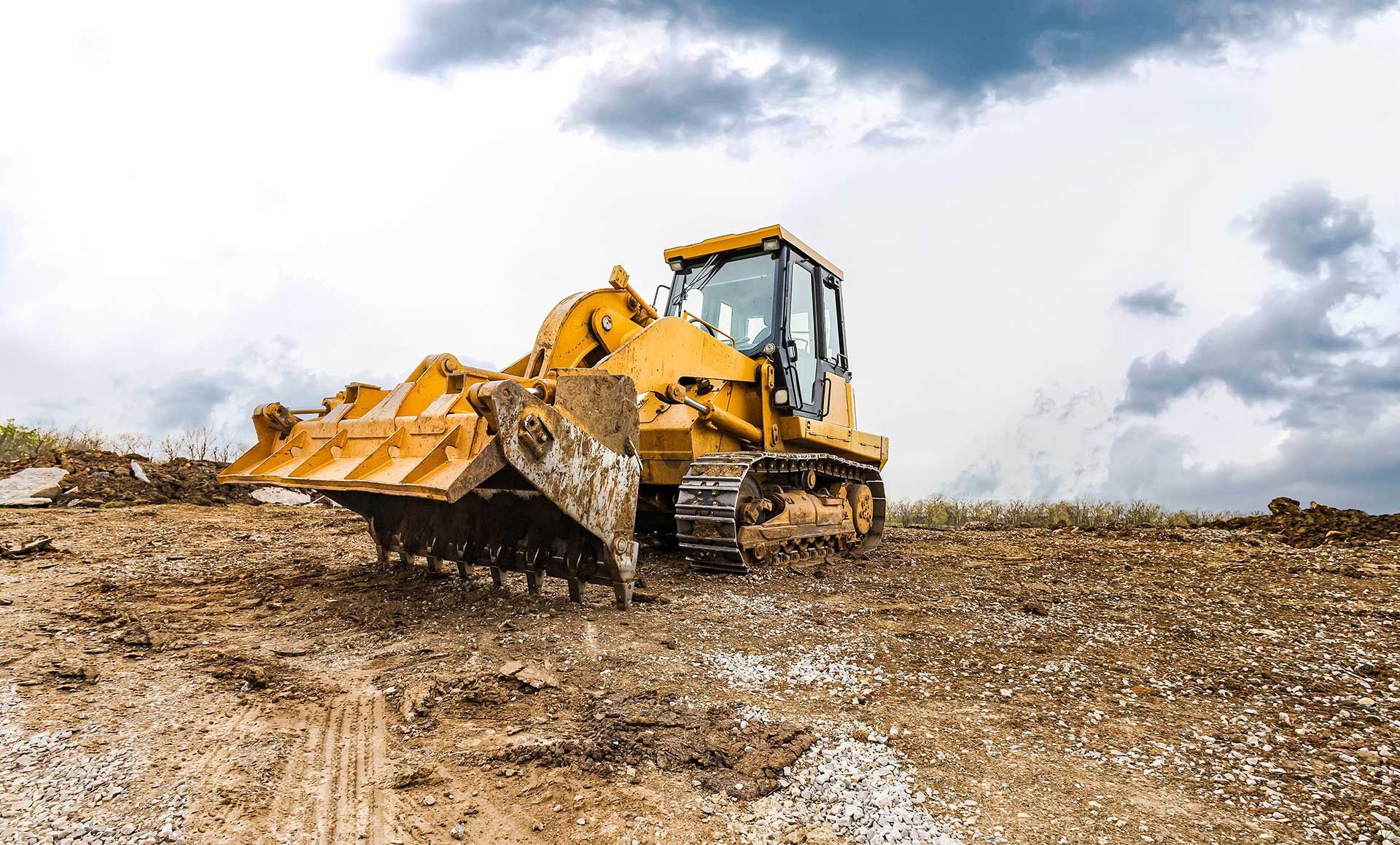 earth-moving equipment at construction site on dull day. 