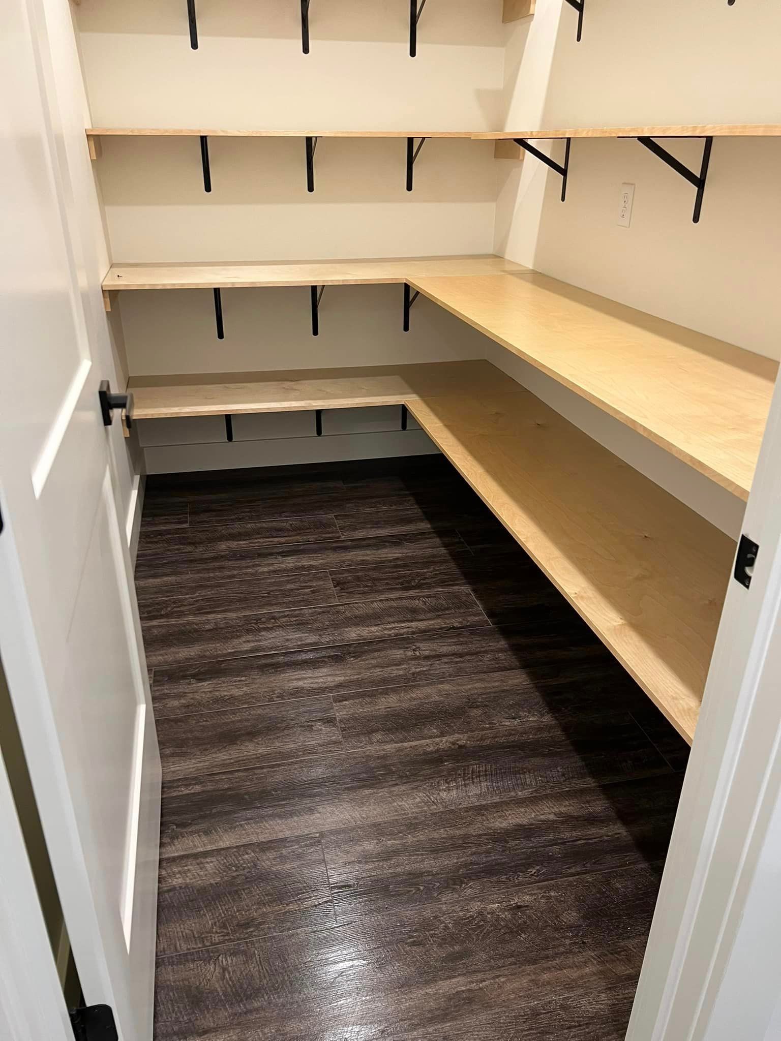 A closet with wooden shelves and a wooden floor.