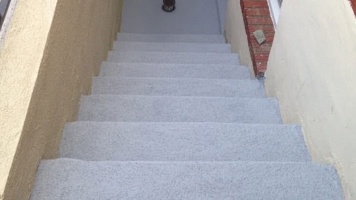 Concrete stairs leading down. Light beige walls on either side.