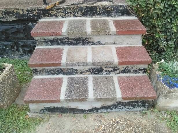 Three-step brick stairs with red, gray, and brown bricks. Concrete base. Outdoor setting.