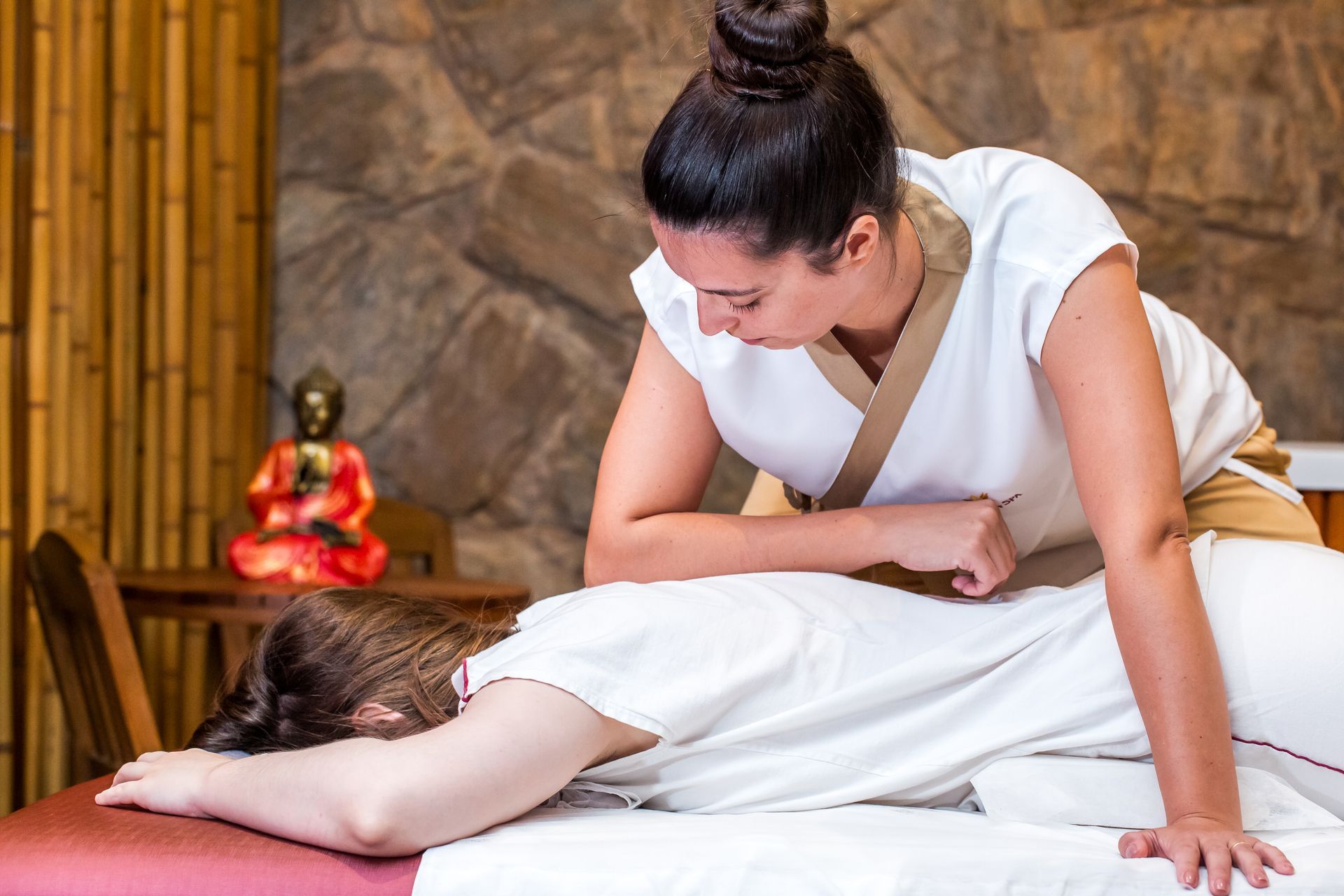 Uma mulher está recebendo uma massagem em um spa ao lado de uma jacuzzi.