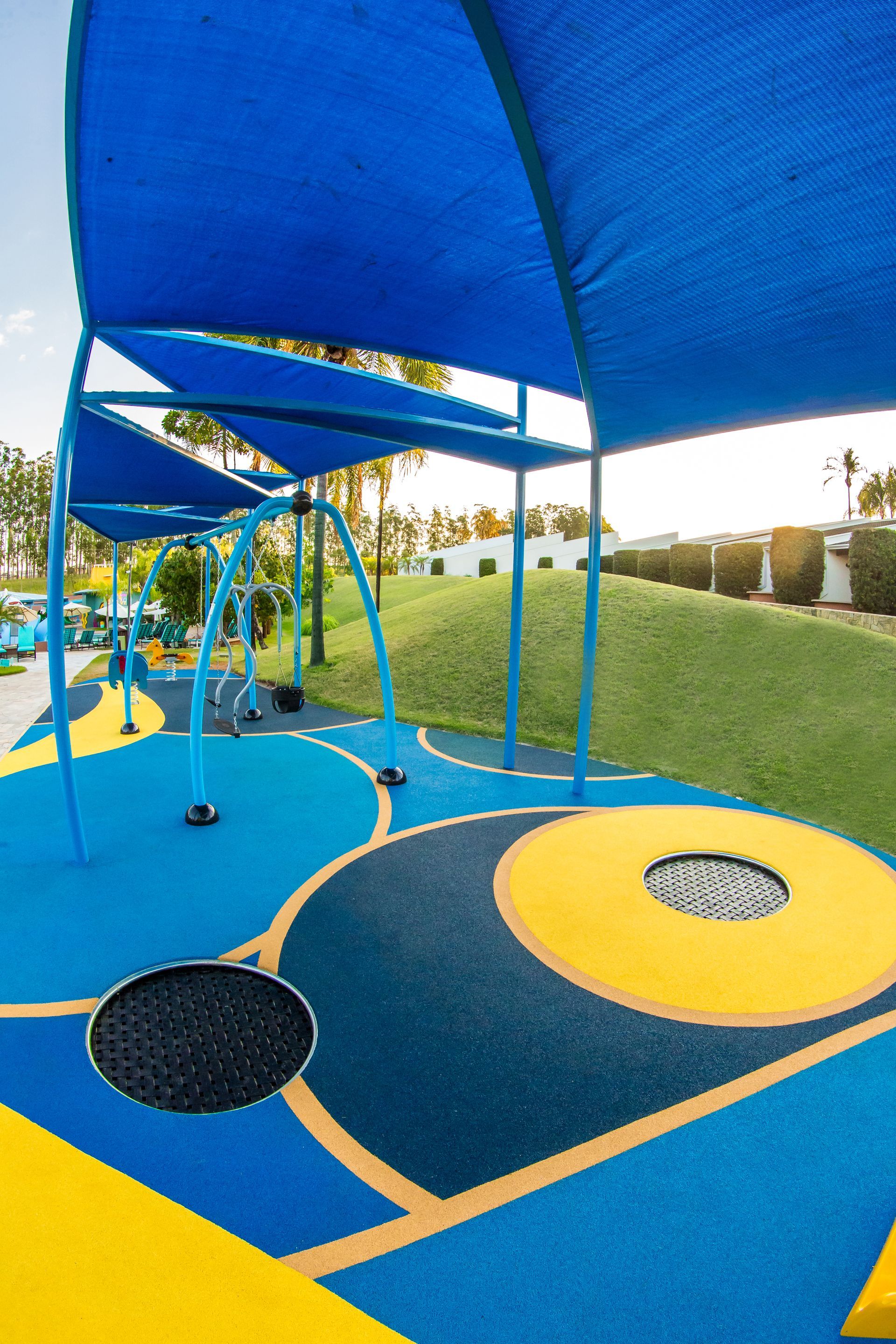 Um playground azul e amarelo com um dossel azul sobre ele.