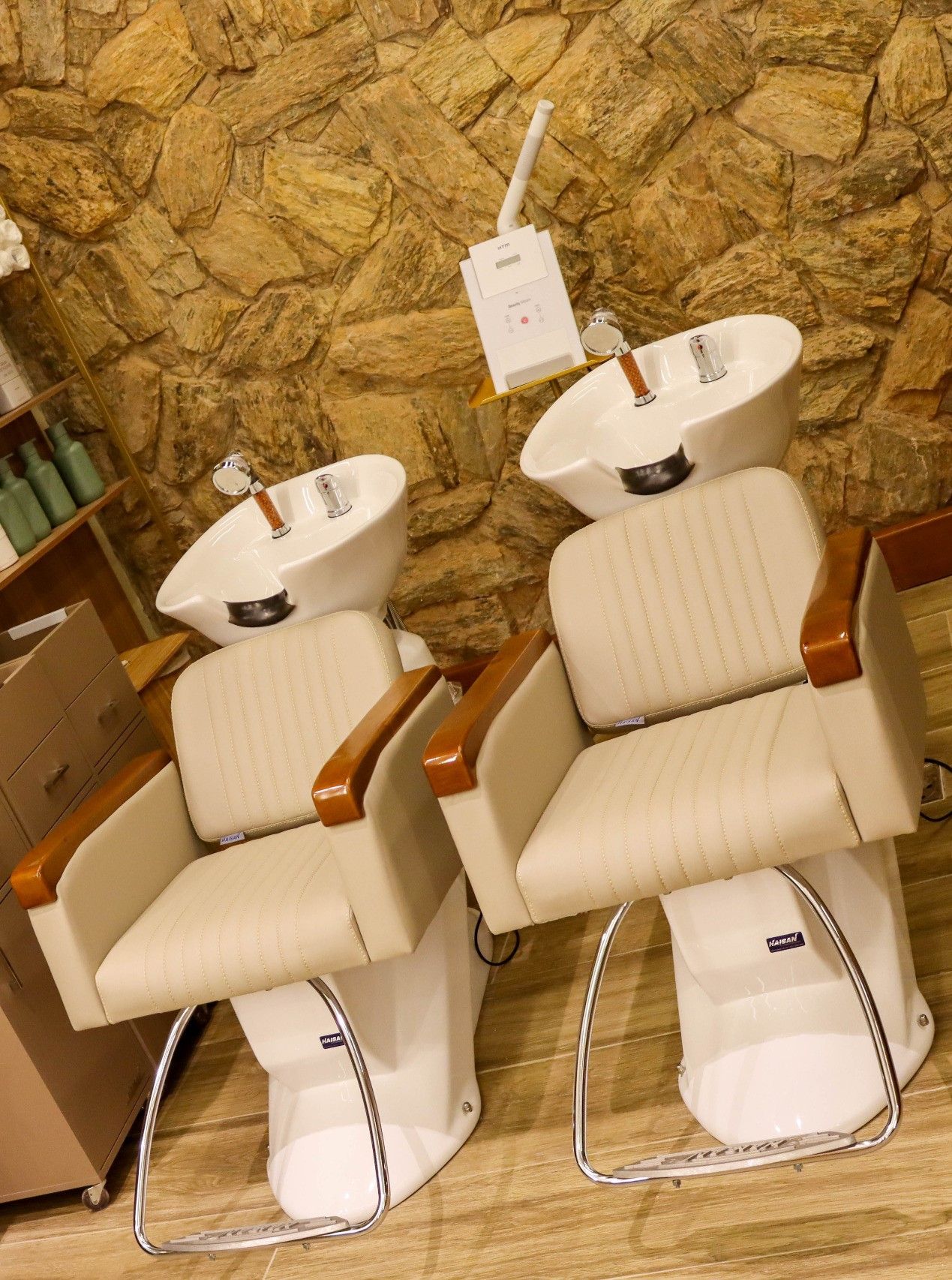 Duas cadeiras estão sentadas uma ao lado da outra em frente a um muro de pedra.