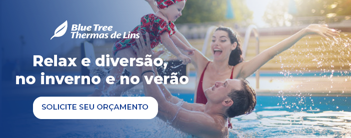 Um homem e uma mulher seguram uma criança em uma piscina.