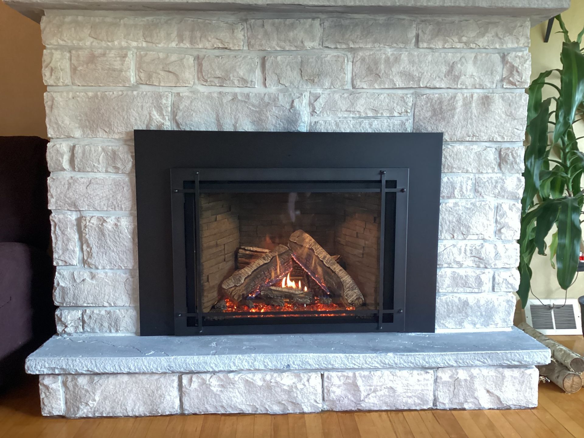 Fireplace with faux-brick surround and black metal trim; flames visible.