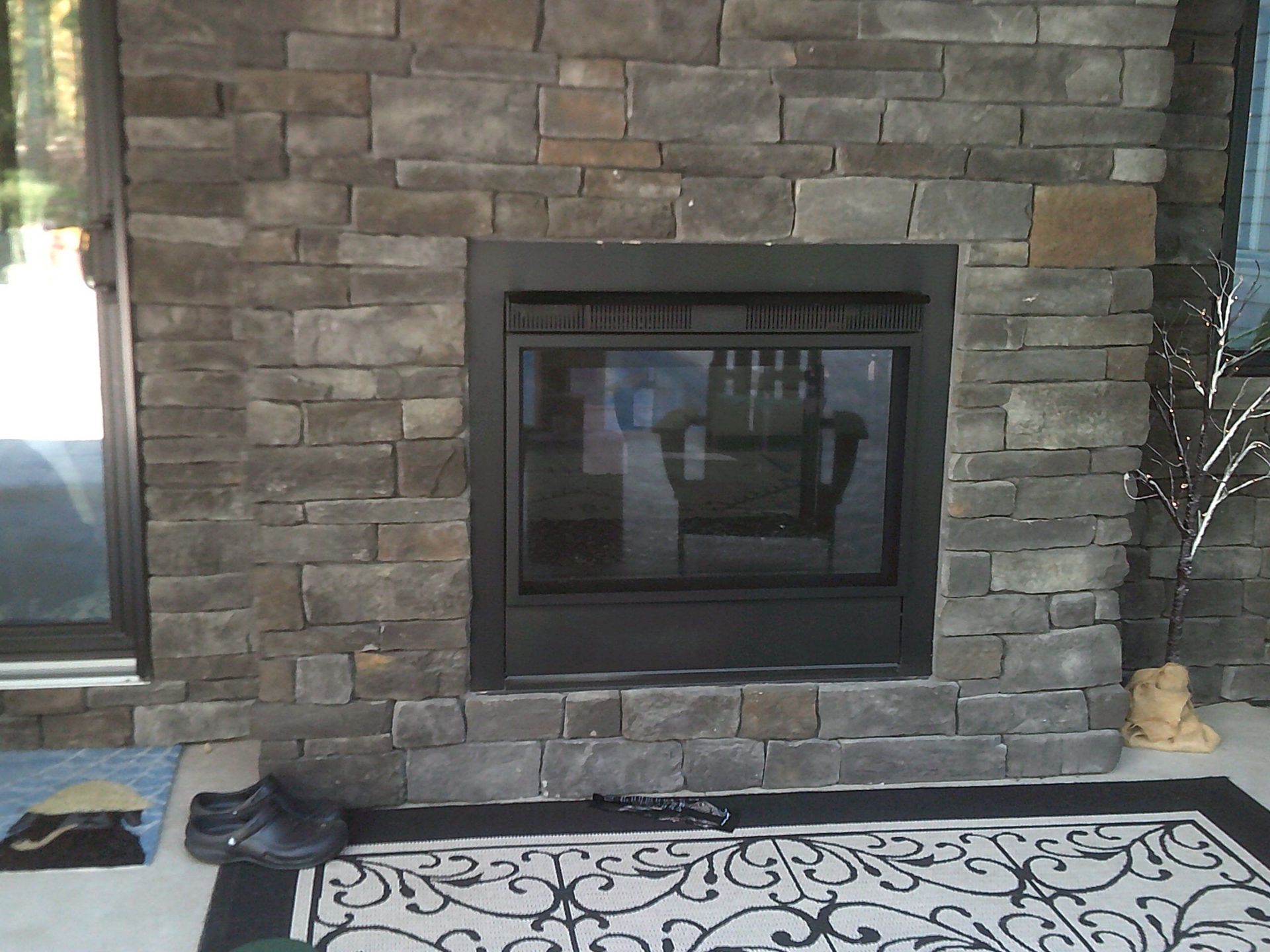 A brick fireplace in a living room with a rug