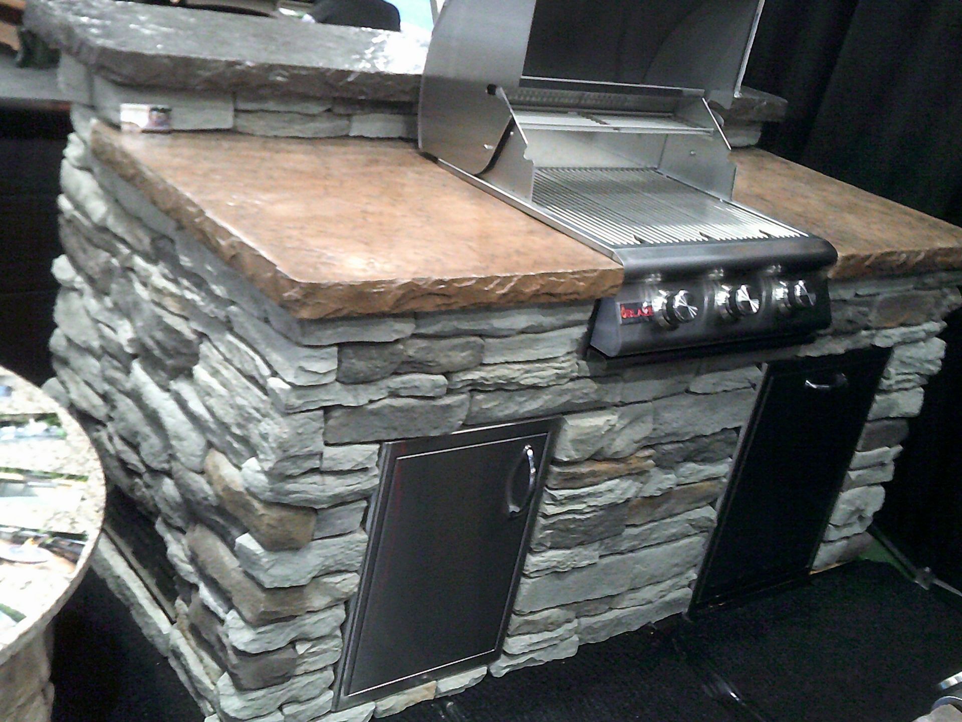A grill is sitting on top of a stone counter top