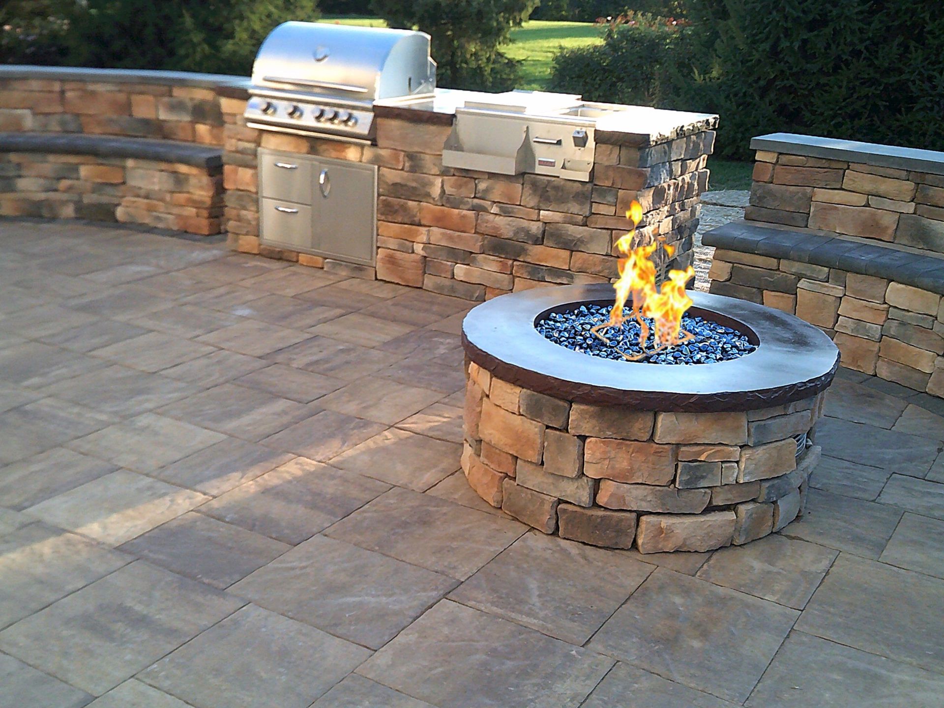 A fire pit with a grill in the background